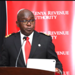 Humphrey Wattanga, KRA Commissioner General, wearing a suit and speaking at an official event on tax reforms.