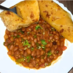 Freshly made Kenyan chapati stacked on a plate, served with beef stew and vegetables.