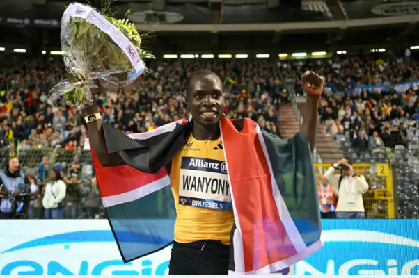 Emmanuel Wanyonyi crosses the finish line with his arms raised in victory after winning the 800m race.