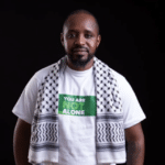 Boniface Mwangi seen smiling at Mombasa airport after his release from Tanzanian custody