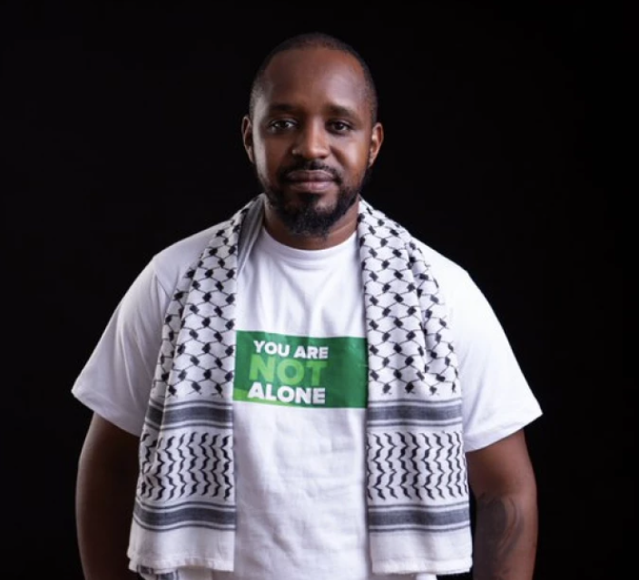 Boniface Mwangi seen smiling at Mombasa airport after his release from Tanzanian custody