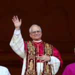 Pope Leo XIV, smiling and waving, stands on the balcony of St. Peter’s Basilica in Vatican City following his election as the first American pontiff.