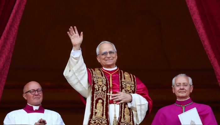 Pope Leo XIV, smiling and waving, stands on the balcony of St. Peter’s Basilica in Vatican City following his election as the first American pontiff.