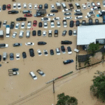 A drone view captures dozens of vehicles submerged in a flooded car park in Hat Yai.